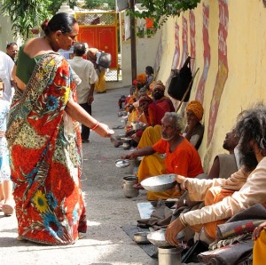 Photograph of woman giving alms to sadhus in Rishikesh, India