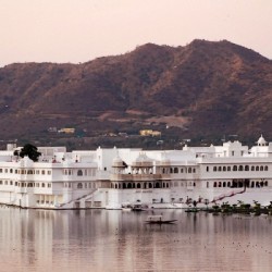 Travel with “Me to We” to India on a life-changing trip Lake Palace Hotel and the pink-hued Aravelli Hills, Udaipur, Rasjasthan, India