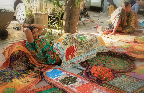 Woman selling tapestries, textiles and wall hangings in Janpath Bazaar, Delhi, India