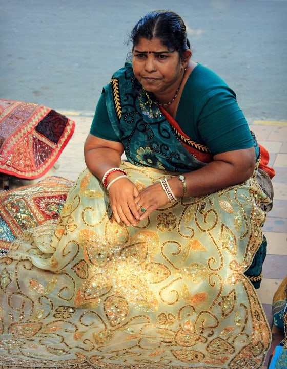 street seller in Janpath Bazaar Delhi selling wall hangings and textiles