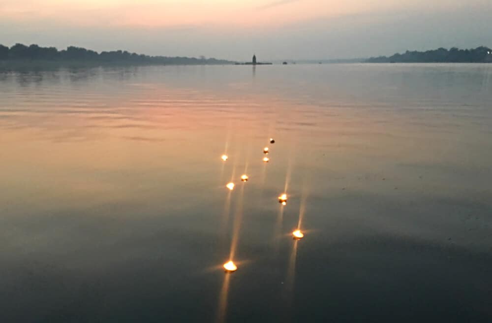 Lght-filled diyas float on the Narmada River in Maheshwar, Madhya Pradesh, India