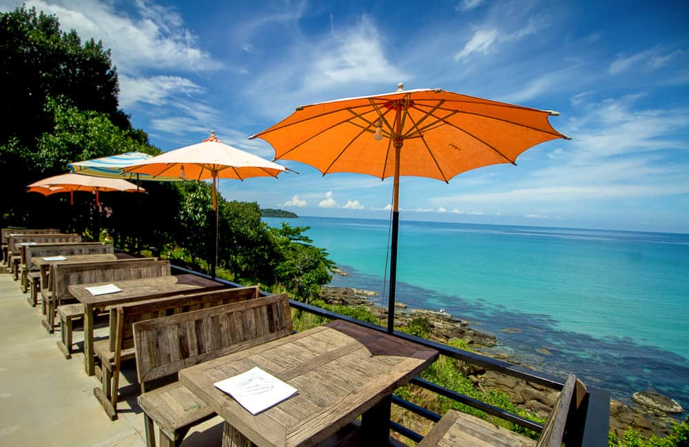 Cafe with orange umbrella overlooking beach in Thailand