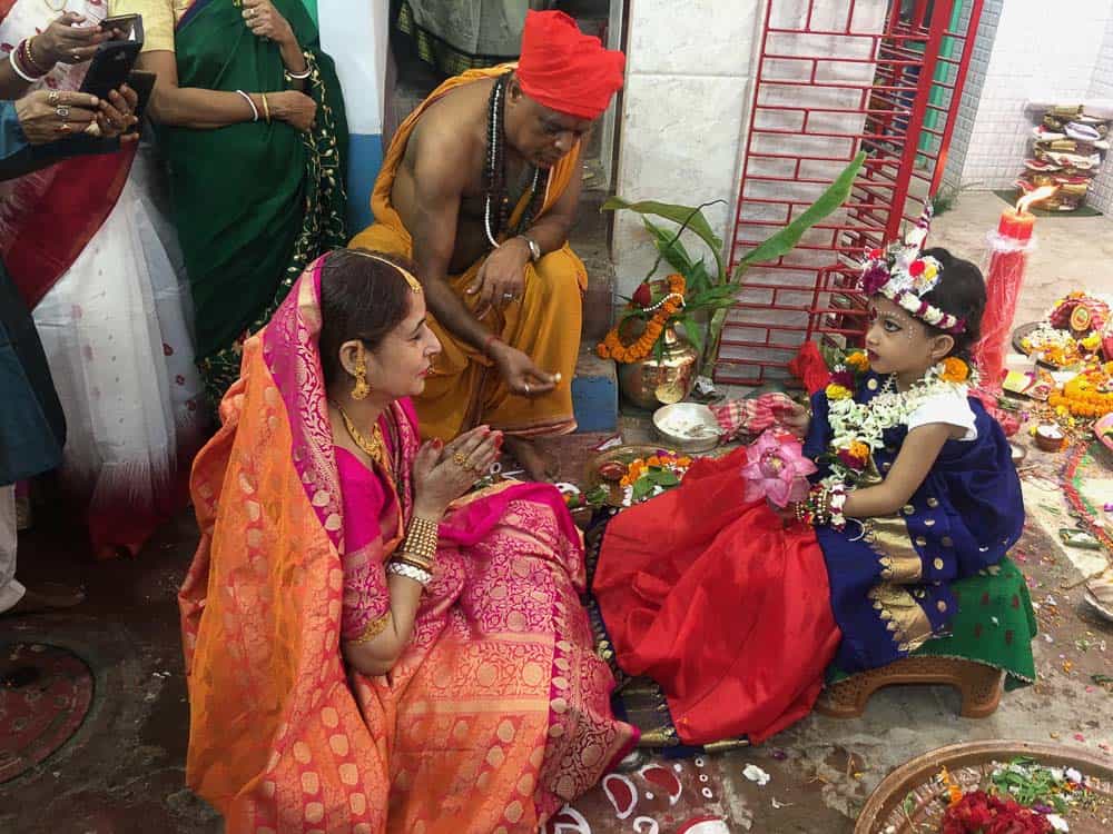 Woman, child, priest at Kumari Puja in Kolkata