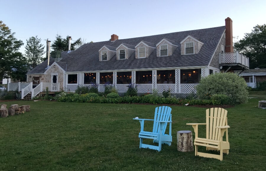 Large wood house with lawn chairs at Inn at Bay Fortune, PEI, Canada