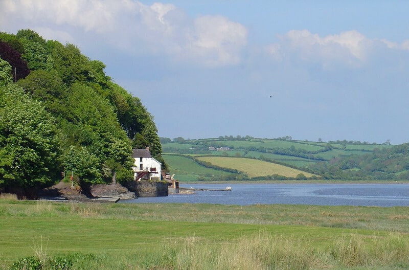 Boat house on a lake with trees, in Laugharne, Wales