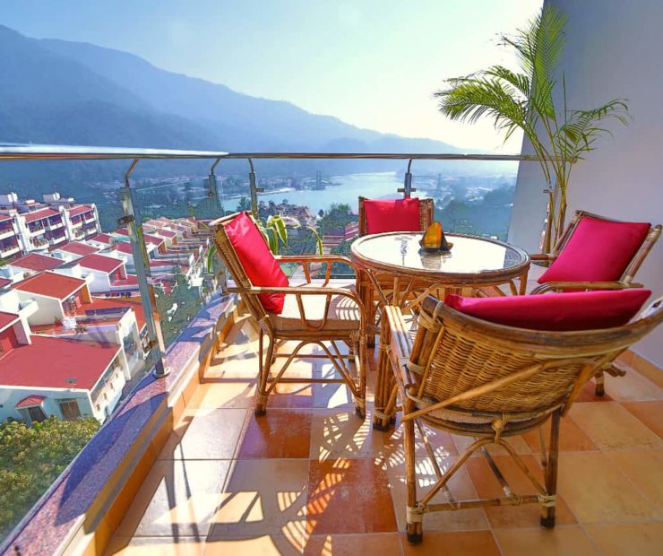 balcony with table and chairs and view of Ganga river at Ayurveda homestay in Rishikesh