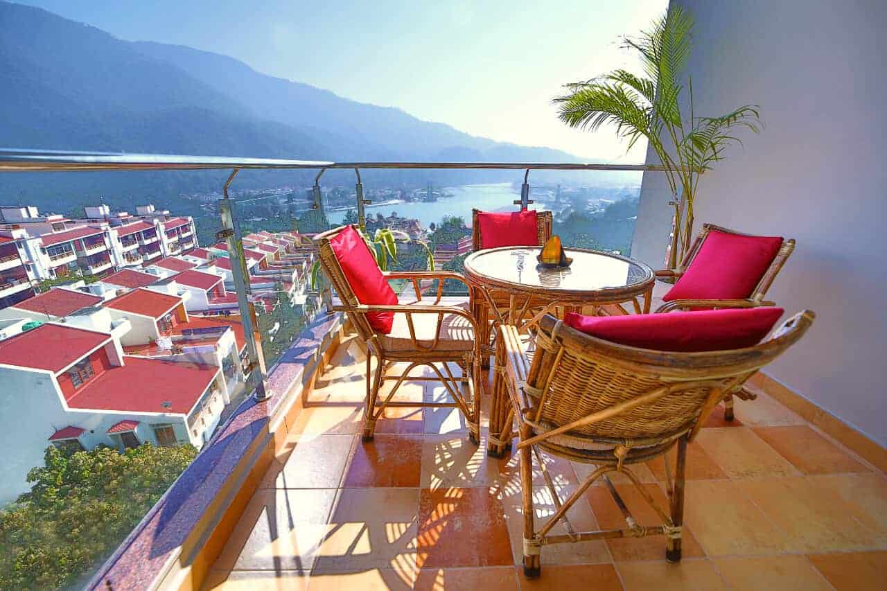 balcony with table and chairs and view of Ganga river at Ayurveda homestay in Rishikesh