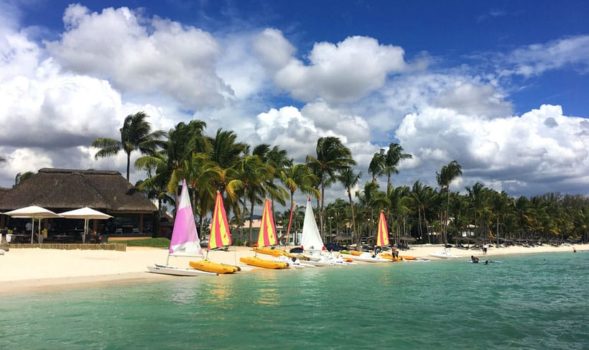 The beautiful beaches, palm trees, blue sky, and sailboats of Mauritius.