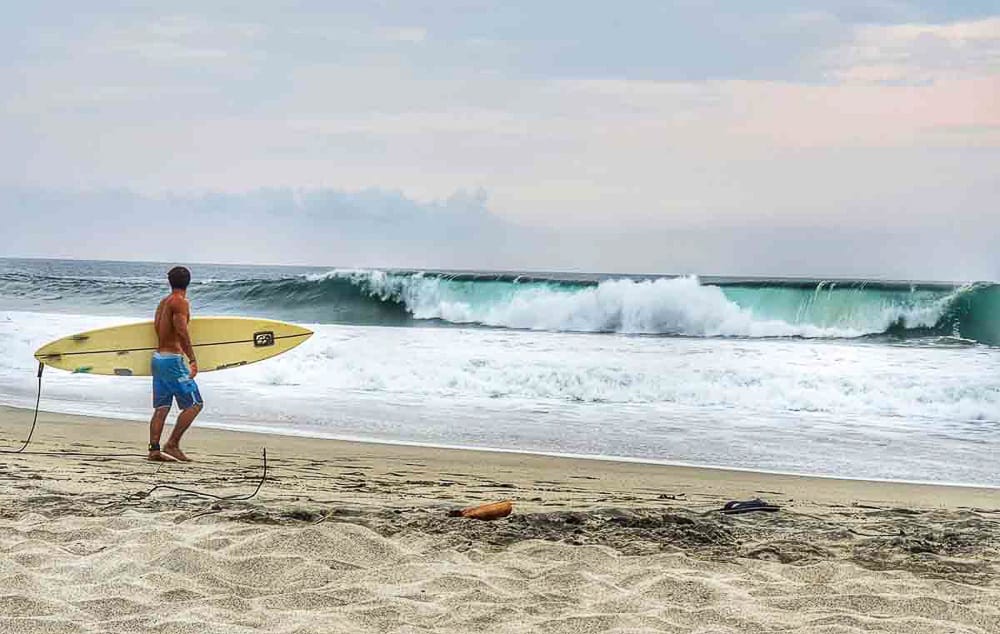 Surfer on Zicatela beach, Puerto Escondido, Mexico during monsoon